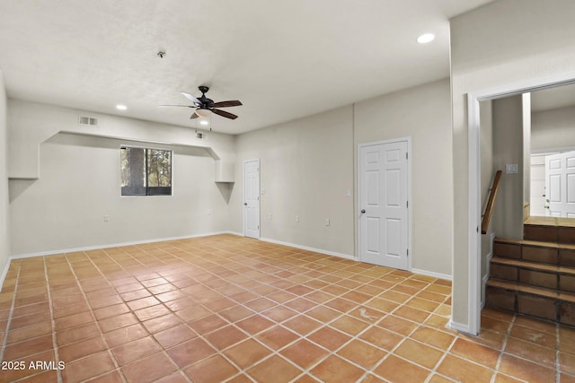 basement with ceiling fan and tile patterned floors