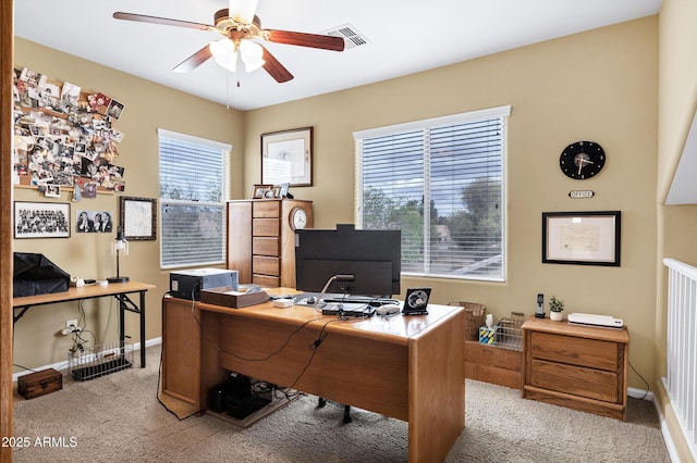 home office with visible vents, light colored carpet, baseboards, and ceiling fan