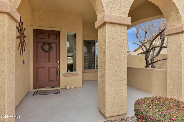 doorway to property featuring stucco siding