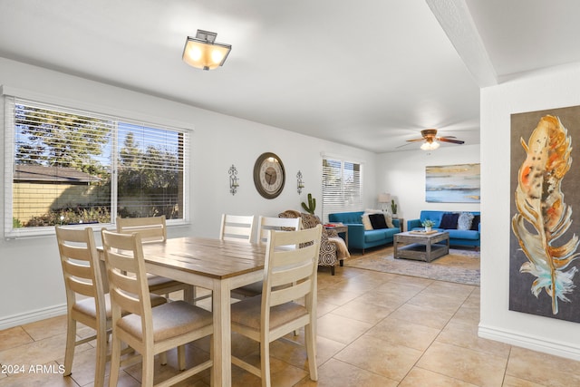 tiled dining space with a healthy amount of sunlight and ceiling fan