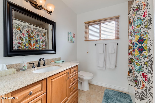 bathroom with tile patterned flooring, vanity, and toilet