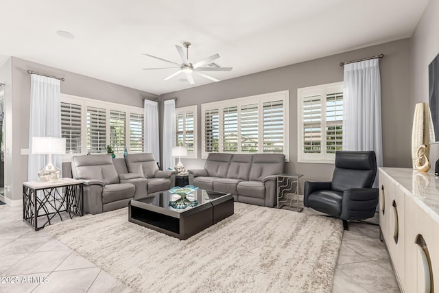 living area with light tile patterned flooring, baseboards, and ceiling fan