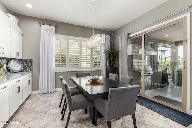dining area featuring baseboards, a healthy amount of sunlight, and light tile patterned floors