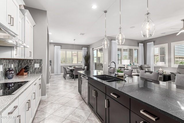 kitchen featuring open floor plan, white cabinetry, black electric cooktop, a sink, and dishwasher
