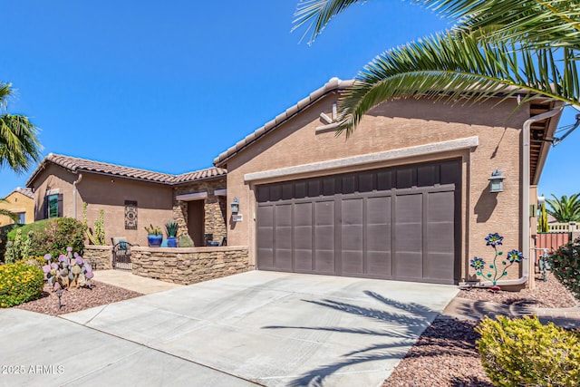 view of front facade with a tile roof, stucco siding, an attached garage, and concrete driveway