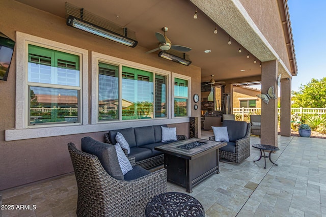 view of patio / terrace featuring ceiling fan, fence, and an outdoor living space with a fire pit