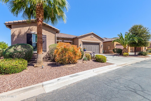 view of front of home featuring a tile roof, stucco siding, a garage, and concrete driveway