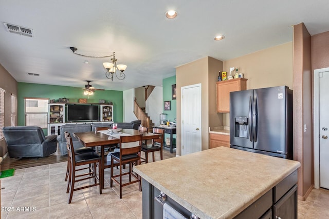 kitchen featuring light brown cabinets, visible vents, light countertops, black fridge with ice dispenser, and ceiling fan with notable chandelier