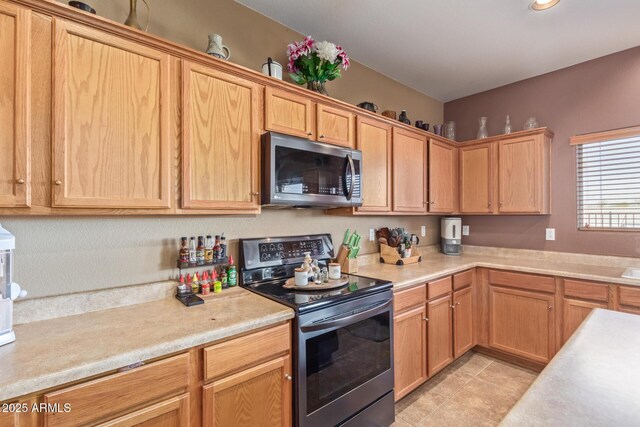 kitchen featuring light tile patterned floors, stainless steel electric range, and light countertops
