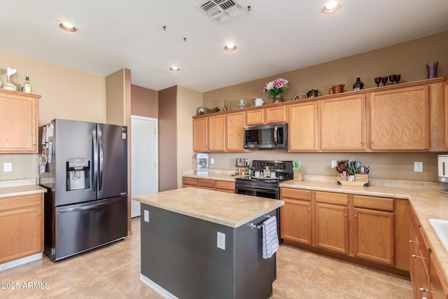 kitchen with a kitchen island, visible vents, stainless steel appliances, and light countertops