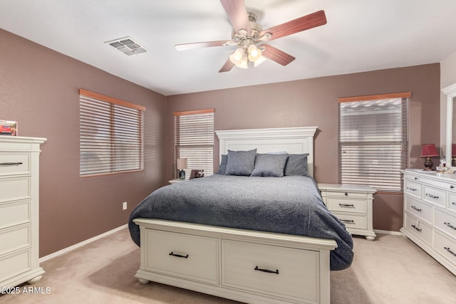 bedroom with visible vents, baseboards, light colored carpet, and ceiling fan