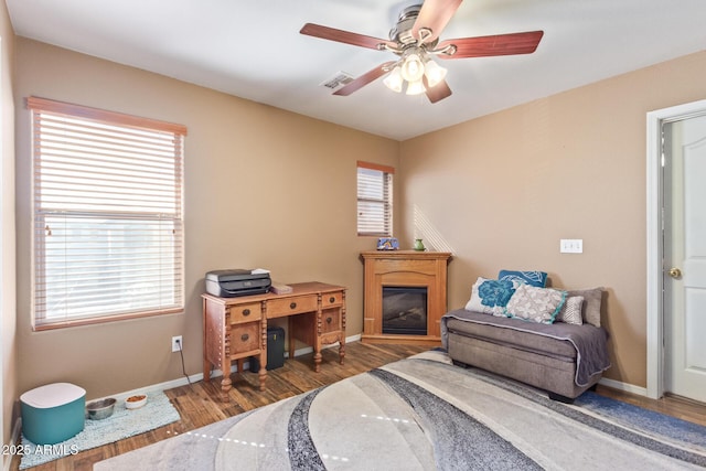 home office featuring visible vents, baseboards, a ceiling fan, and wood finished floors