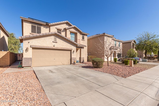 view of front of home featuring a gate, fence, stucco siding, concrete driveway, and a tiled roof