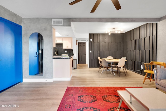 dining area featuring light hardwood / wood-style floors, ceiling fan, and sink