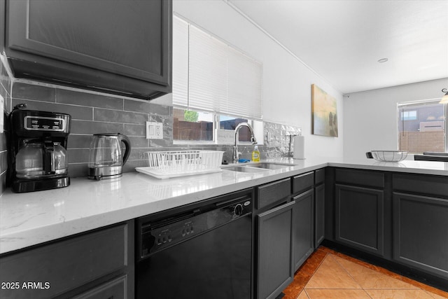 kitchen with a sink, tasteful backsplash, black dishwasher, and a wealth of natural light