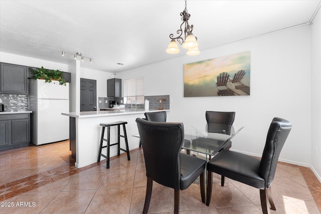 dining space with light tile patterned flooring and an inviting chandelier