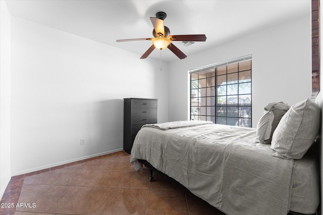 tiled bedroom featuring baseboards and ceiling fan