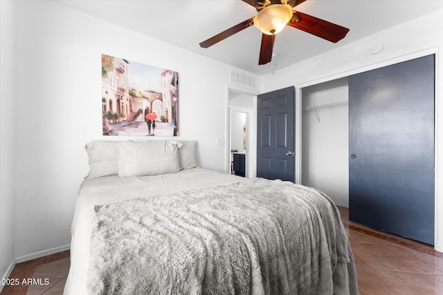 bedroom with tile patterned flooring, visible vents, a closet, and ceiling fan