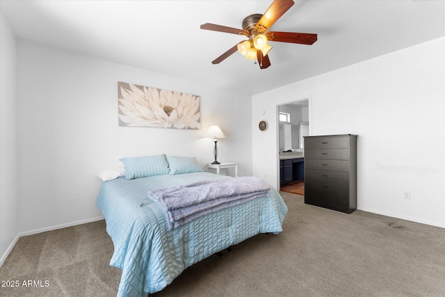 carpeted bedroom with ensuite bathroom, baseboards, and ceiling fan