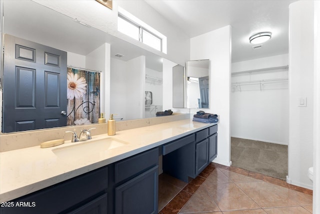 bathroom with visible vents, baseboards, a spacious closet, vanity, and tile patterned flooring