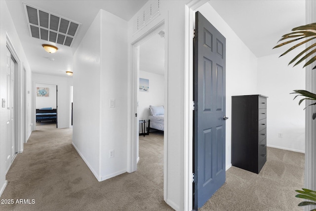 hallway featuring carpet, visible vents, and baseboards