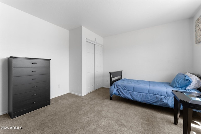 bedroom with a closet, baseboards, and carpet