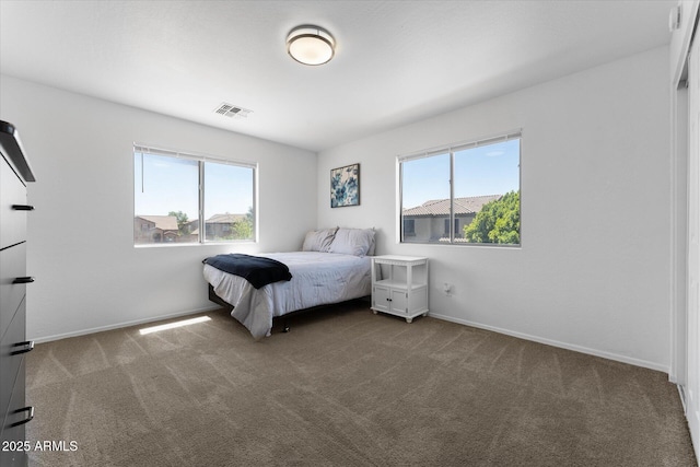 carpeted bedroom with baseboards, multiple windows, and visible vents