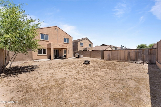 exterior space featuring a patio, a fenced backyard, and a fire pit