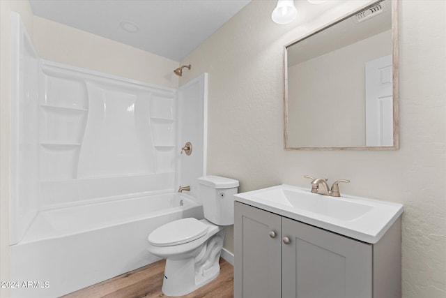 full bathroom featuring hardwood / wood-style floors, vanity, toilet, and shower / washtub combination