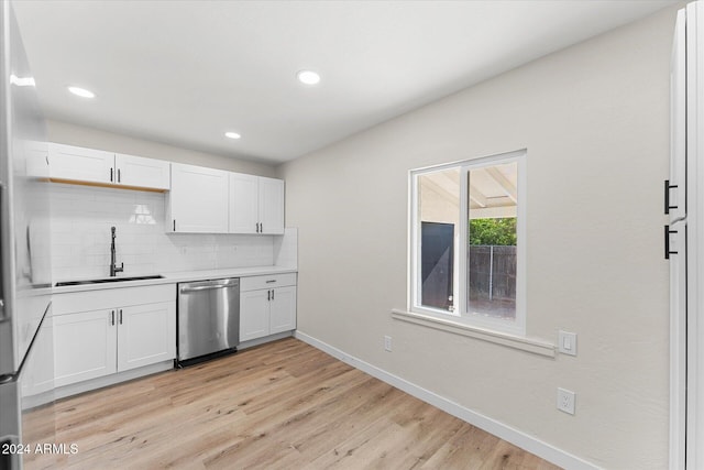 kitchen with tasteful backsplash, sink, dishwasher, light hardwood / wood-style floors, and white cabinetry