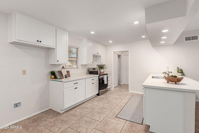 kitchen featuring stainless steel electric range oven, sink, white cabinets, and kitchen peninsula