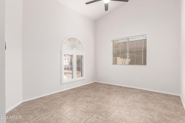 tiled empty room with ceiling fan and high vaulted ceiling