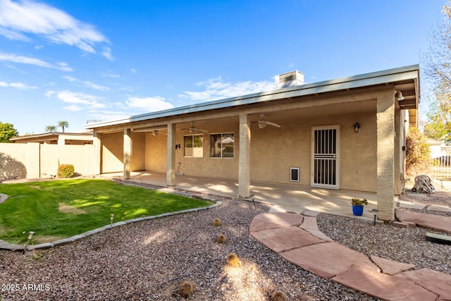 rear view of property with a yard, a patio area, and ceiling fan