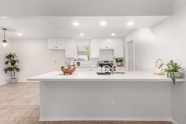 kitchen with light tile patterned flooring, sink, white cabinetry, decorative light fixtures, and kitchen peninsula