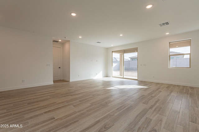 unfurnished room featuring a wealth of natural light and light hardwood / wood-style floors