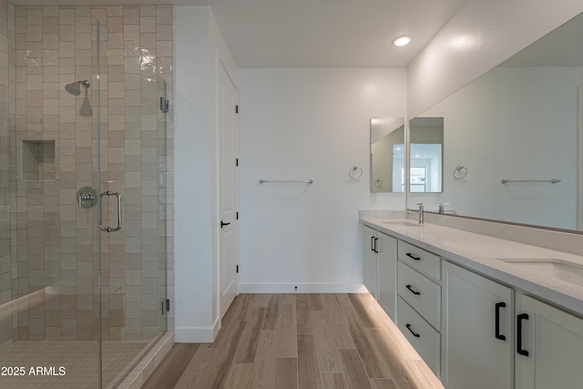 bathroom featuring wood-type flooring, vanity, and an enclosed shower