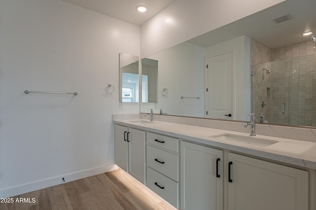 bathroom with vanity, hardwood / wood-style flooring, and a shower with shower door