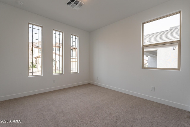 carpeted spare room featuring a wealth of natural light