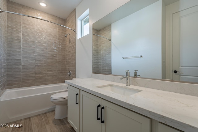 full bathroom featuring toilet, vanity, tiled shower / bath combo, and hardwood / wood-style flooring