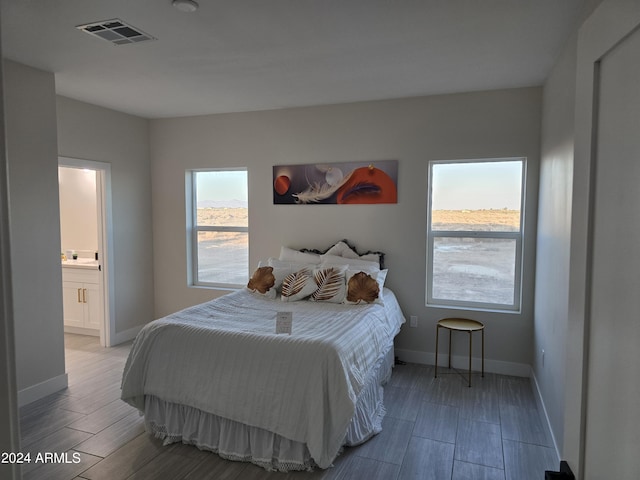 38422 W Buckeye Rd, Tonopah, AZ 85354 - bedroom featuring baseboards, visible vents, wood tiled floor, and ensuite bathroom