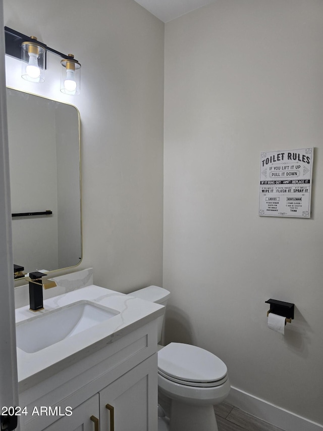 38422 W Buckeye Rd, Tonopah, AZ 85354 - half bathroom with toilet, wood finished floors, vanity, and baseboards