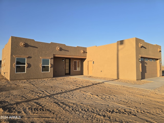 38422 W Buckeye Rd, Tonopah, AZ 85354 - rear view of house featuring stucco siding, driveway, and a garage