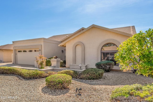 view of front of home with a garage and stucco siding