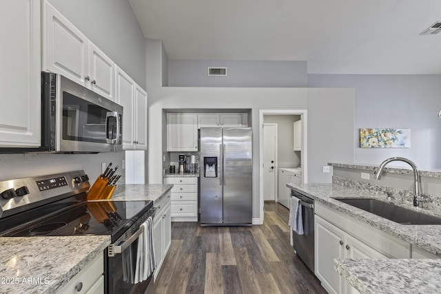kitchen featuring visible vents, a sink, stainless steel appliances, white cabinetry, and dark wood-type flooring