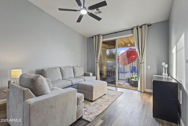 living room with a ceiling fan, visible vents, wood finished floors, baseboards, and lofted ceiling