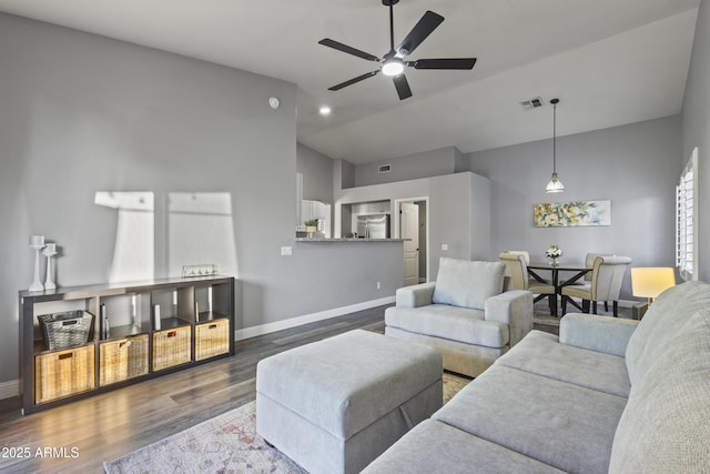 living area featuring visible vents, wood finished floors, baseboards, high vaulted ceiling, and a ceiling fan