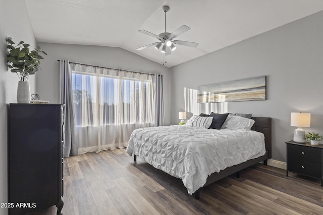 bedroom with baseboards, ceiling fan, wood finished floors, and vaulted ceiling