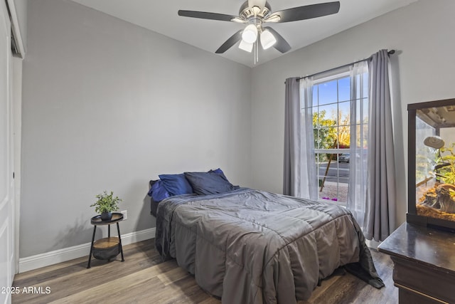bedroom featuring baseboards, ceiling fan, and wood finished floors