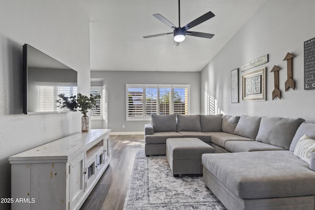living area featuring baseboards, ceiling fan, wood finished floors, and lofted ceiling