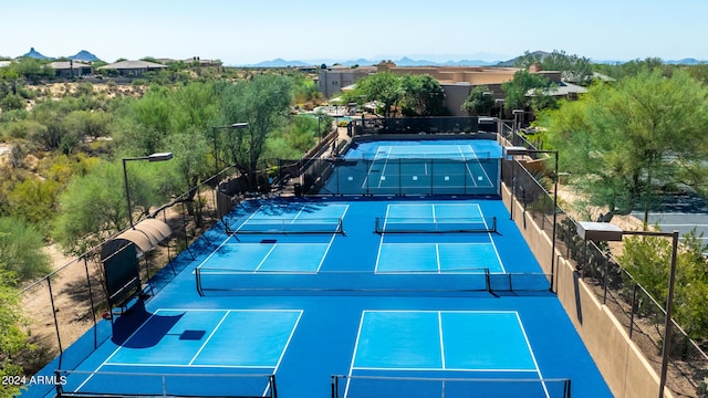 view of sport court with a mountain view and fence